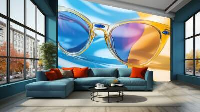 Stylish sunglasses with colorful lenses on a vibrant yellow and blue background, perfect accessory for summer fashion and outdoor activities. Wall mural