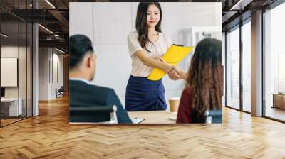 Young Asian woman graduate hand shake with two manager to welcome before start to job interview with positive motion in meeting room,Business Hiring new member,Job interview first impressions concept Wall mural