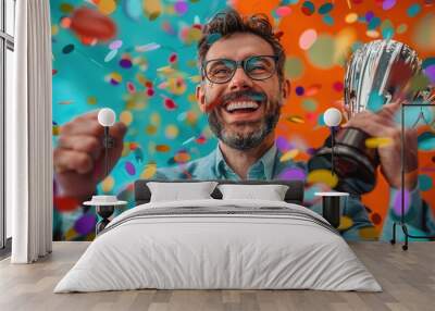 Joyful man in suit celebrating victory with trophy and colorful confetti background, expressing excitement and success. Wall mural