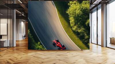 An aerial view of a race car skillfully navigating a twisty road surrounded by lush greenery, capturing the thrill of speed. Wall mural