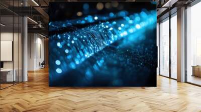 A close-up of high-speed fiber optic cables glowing with blue light in a dark room, showcasing the advanced technology used for modern internet connections and data transmission.  Wall mural