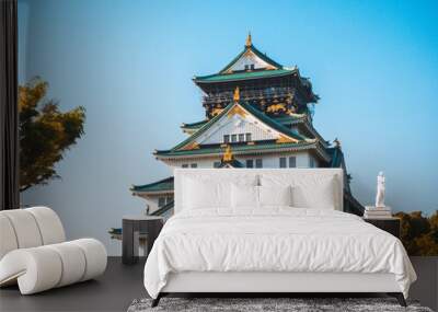 majestic osaka castle stands tall, surrounded by vibrant cherry blossoms. its elegant architecture r Wall mural