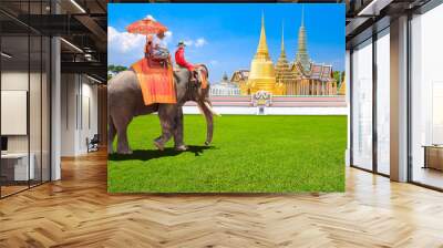 Tourists on an ride tour Elephant of The Buddhist temple of Wat Phra Kaeo at the Grand Palace in beautiful sky at Bangkok,Thailand Wall mural