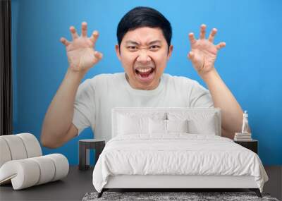 Man gesture scared at you,Asian man hand up gesture horror blue background Wall mural