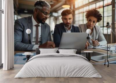 Strategic Collaboration: A diverse business team huddles around a laptop, intensely focused on data analysis and project planning in their modern office. Wall mural