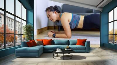 Portrait beautiful adult (40 years old) Asian woman doing Home Workout in Sports Clothing with Stretching Exercise in the room white background. Wall mural