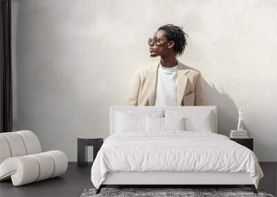 Stylish man in sunglasses posing against a minimalist wall Wall mural