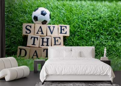 Soccer ball with save the date on green grass for party invitation Wall mural