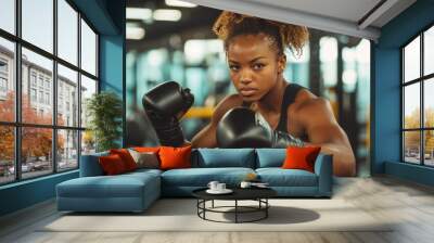 A Woman Throwing Punches in a Boxing Gym for Exercise and Training Wall mural