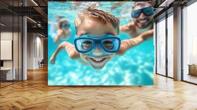 A little boy and his family swim underwater in a swimming pool during summer vacation Wall mural