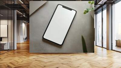 A Mock up of an blank smartphone with laptop on table, Top view of modern office space  Wall mural