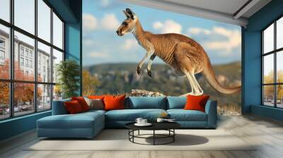 A red kangaroo leaps over a rocky outcrop in the Australian outback Wall mural