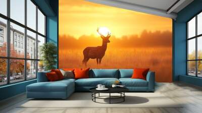 A serene silhouette of a deer standing gracefully in a golden field during a stunning sunset.  Wall mural