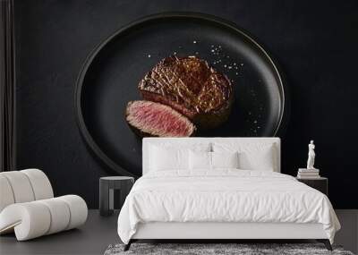 Freshly seared steak fillet cut from a beef tenderloin placed on a dark plate against a simple minimalist background The steak is cooked to a perfect medium rare Wall mural