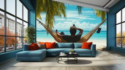 rear view of man traveler with mobile phone relax in hammock on summer beach  Wall mural