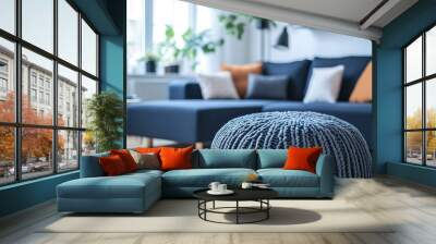 Two knitted poufs near dark blue corner sofa. Scandinavian home interior design of modern living room  Wall mural