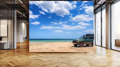 Off-road SUV on sandy beach under blue sky with clouds. Adventure travel and exploration concept. Wall mural