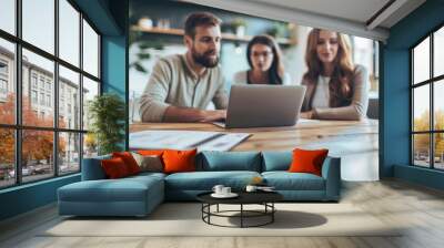 Three people are sitting at a table with a laptop open in front of them Wall mural