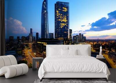 A modern city skyline at dusk, with glowing lights and tall skyscrapers Wall mural