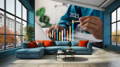 Businessman analyzes profitability of working companies with digital augmented reality graphics, positive indicators in 2023, businessman calculates financial data for long-term investments. Wall mural