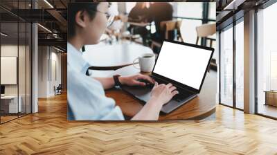 Close-up image of a woman sitting in the cafe and using her laptop.  laptop white blank screen mockup for display your graphic banner. Wall mural