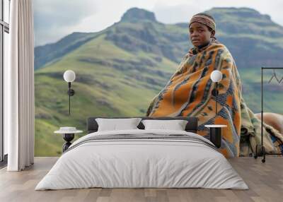 Lesotho Teenager on Horseback: Candid Moment with Basotho Blanket and Majestic Mountain Background Wall mural