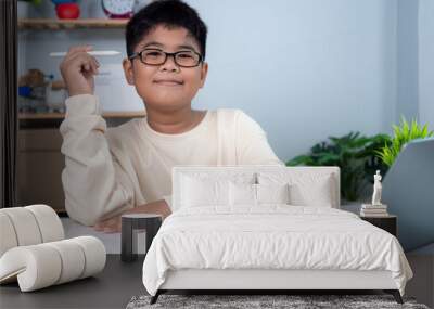 Little Asian boy student using computer laptop learning. Educational of tech concept, Staying at home, Presenting a modern educational way of life. Virtual internet online class from school teacher. Wall mural