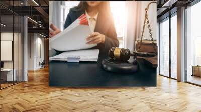 Beautiful young woman lawyer sitting in front of laptop in room with documents and smartphone with empty hammer and scale next to it justice and legal concept Wall mural