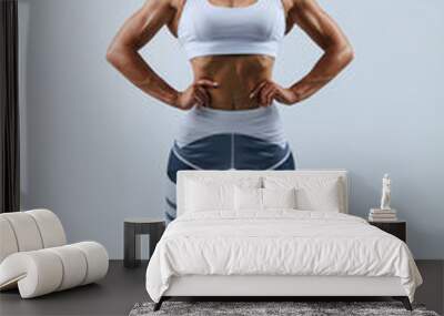 confident muscular woman standing with hands on the hips, full length photo, isolated white background, studio shot Wall mural