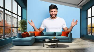 happy successful man rejoicing at big sales on clothes, happiness, unexpected good fortune, victory of his favourite team. studio shot Wall mural