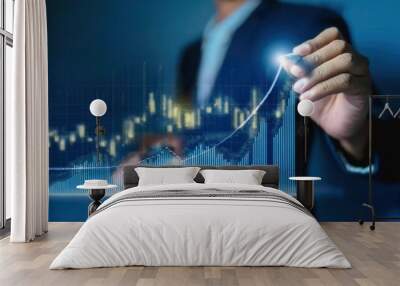 A businessman draws an upward arrow on a holographic graph, symbolizing growth and success in business. Wall mural