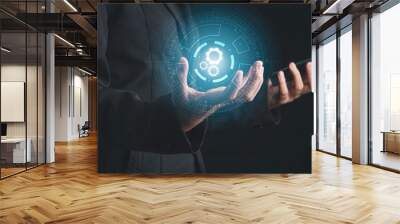 Digital workflow, Digital transformation, Automatic technology concept. Businessman holding digital machine gears  icons in cyber circle and holding smartphone. Wall mural