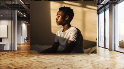 Cinematic side view portrait of teenage African American boy sitting on bed with dramatic light and shadow copy space : Generative AI Wall mural