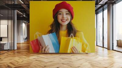 Full body young happy woman wears red hat hold shopping paper package bags stand near rack of casual clothes do winner gesture isolated on plain yellow background Black Friday sale buy : Generative AI Wall mural