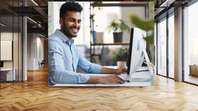 Smiling young middle eastern businessman sitting at worktable at modern office typing on computer keyboard sending emails to his business partners working on marketing research copy sp : Generative AI Wall mural