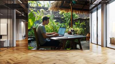 Young digital nomad working remotely on his laptop in Bali Freelancer Man in workation video call Travel and remote online work Outdoor in the garden desk for  remote workers someone a : Generative AI Wall mural