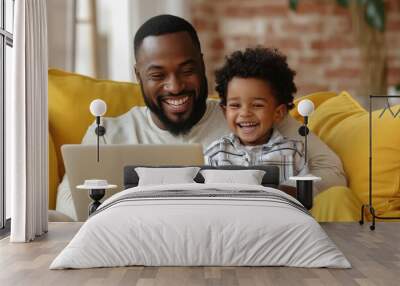 excited father and son laughing while sitting on yellow sofa with laptop, Generative AI Wall mural