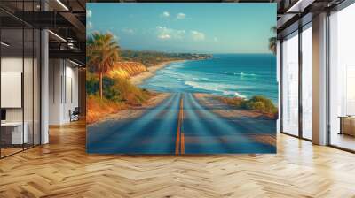 A serene coastal highway with sparkling waves crashing on the shore, framed by palm trees. Wall mural