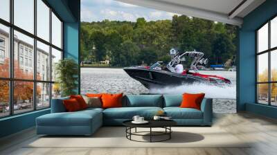 Boater on gray wakeboard wake boat enjoying summer day on freshwater lake. Wall mural