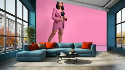 Beautiful smiling young african American business woman in Pink Suit, Black T-shirt standing,posing isolated on pink background. Achievement career wealth business concept. Mock up copy space.  Wall mural