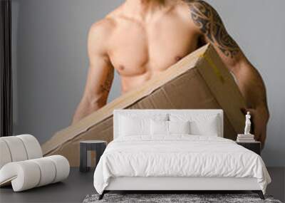 athletic, shirtless young man carrying big cardboard box Wall mural