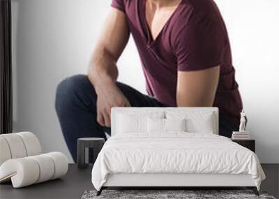 Full body shot of handsome young man sitting on floor Wall mural