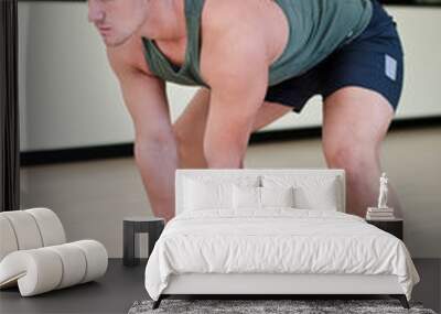 Handsome young man working out in gym with kettlebell Wall mural