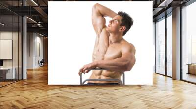 Muscular young bodybuilder sitting on chair Wall mural