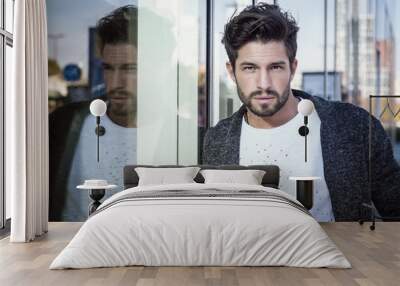 One handsome young man in urban setting in European city, standing Wall mural