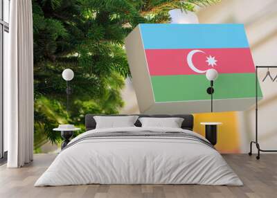 Azerbaijan flag printed on a Christmas gift box. Printed present box decorations on a Xmas tree branch on a street. Wall mural