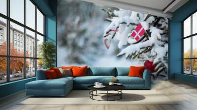 Denmark Christmas. Christmas tree covered with snow and a flag of Denmark. Danish flag closeup. Winter background scene outdoor.  New Year or Xmas holiday greetings card Wall mural