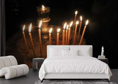 Lighting candles inside a Greek orthodox church. Wall mural