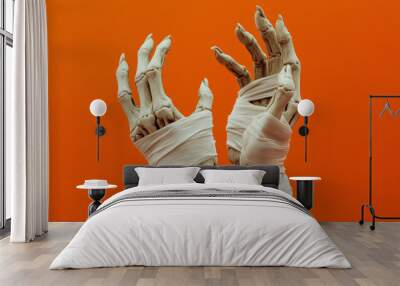 Mummified halloween hands wrapped in bandages against a orange background. Halloween, costume mummy Wall mural