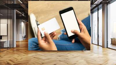 Woman of color holding a bank card and a cell phone Wall mural